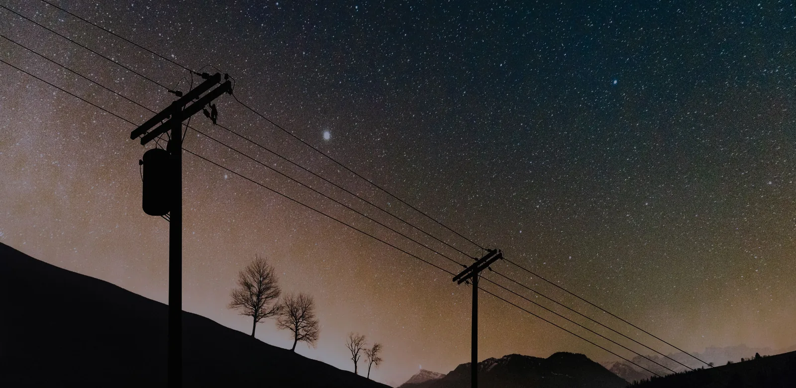 Línea de distribución al anochecer bajo un cielo estrellado